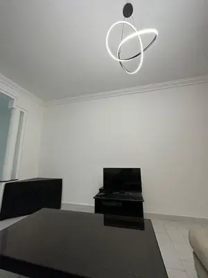 a living room with a table and a chandelier at Appartement 3 chambres salon à coté de éden et Mcdo 6 in Marrakech