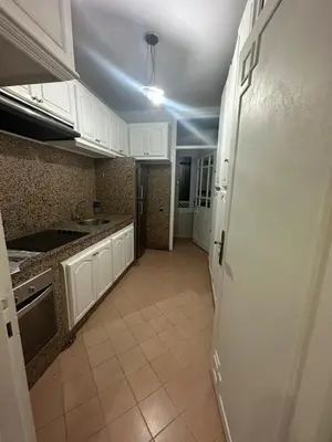 a kitchen with white cabinets and a white refrigerator at Appartement 3 chambres salon à coté de éden et Mcdo 6 in Marrakech