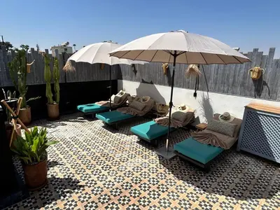 a group of chairs and an umbrella on a patio at Riad Be Colors in Marrakech