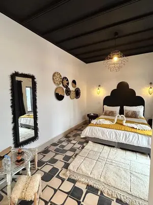 a bedroom with a large bed and a mirror at Riad Be Colors in Marrakech