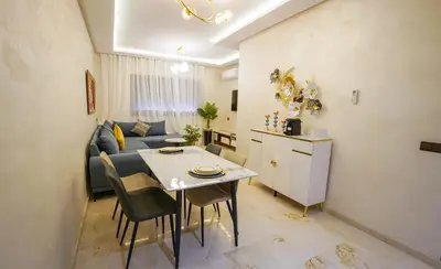 a small living room with a table and a couch at Charmant appartement in Marrakech