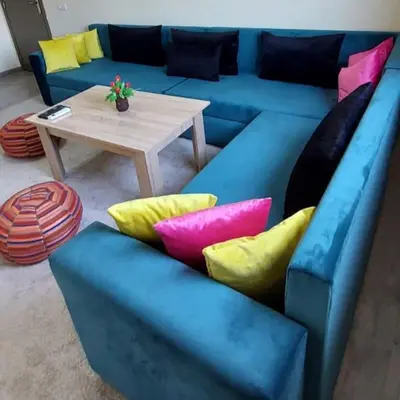 a blue couch with colorful pillows and a table at Apartment in Marrakech - WiFI - IPTV Movies - equipped - free parking in Marrakech