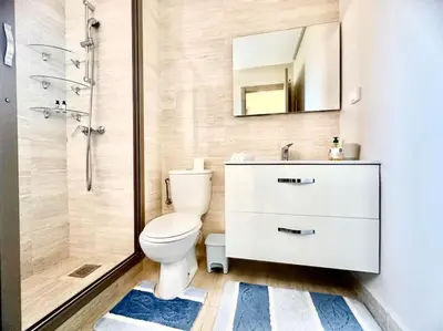 a bathroom with a toilet and a sink and a shower at Appartement Spacieux et Moderne avec une Vue sur Montagne et Piscine in Marrakech