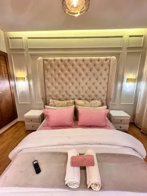 a bedroom with a large bed with pink pillows at Appartement Luxueux avec Piscine 10 minutes du centre ville in Marrakech