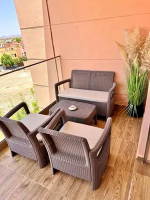 a patio with two chairs and a table and a couch at Appartement Luxueux avec Piscine 10 minutes du centre ville in Marrakech