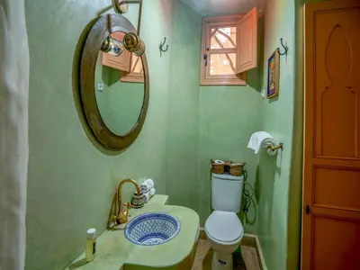 a bathroom with a toilet and a sink and a mirror at Riad Nakhla in Marrakech