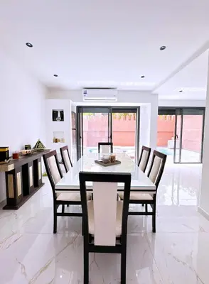 a dining room with a glass table and chairs at Villa Jassmin, piscine, à 6km du centre ville in Marrakech