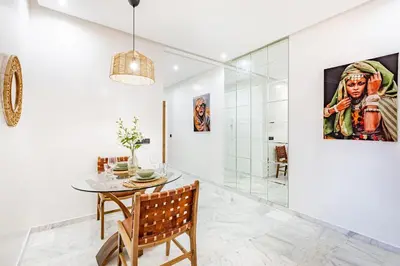 a dining room with a table and a glass shower at Starlight Studio in Marrakech