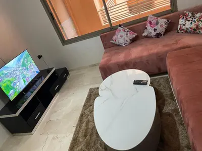 a living room with a couch and a television at Appartement à louer Marrakech in Marrakech