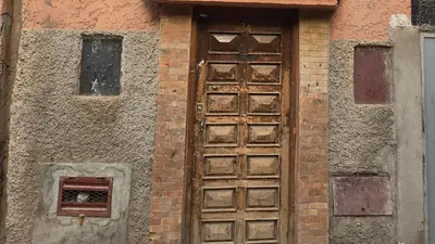 an old wooden door on the side of a building at Riad Sleeps 2 with Rooftop Views in Marrakech