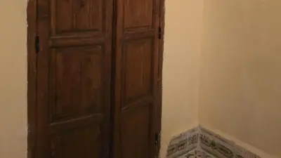 an open wooden door in a corner of a room at Riad Sleeps 2 with Rooftop Views in Marrakech