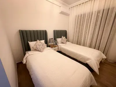 two beds sitting in a room with a window at Grand appartement moderne in Marrakech