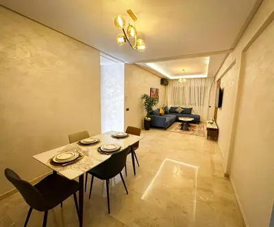 a dining table and chairs in a living room at Grand appartement moderne in Marrakech