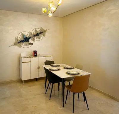 a dining room with a table with chairs and a refrigerator at Grand appartement moderne in Marrakech