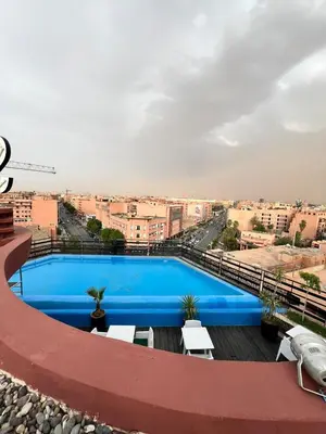 a large blue swimming pool on top of a building at La Renaissance hôtel Marrakech in Marrakech