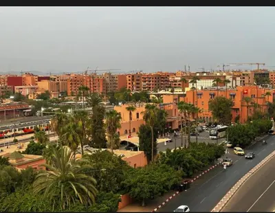 a city with a street with cars and buildings at Nour 5 in Marrakech