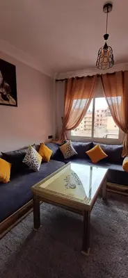 a living room with a blue couch and a glass table at Résidence Nadia 3 étage appartement 22 in Marrakech