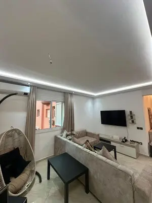 a living room with a couch and a flat screen tv at Centre ville T3 jacuzzi privé 2 min de la gare in Marrakech