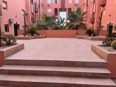 a courtyard in the middle of a building with stairs at Centre ville T3 jacuzzi privé 2 min de la gare in Marrakech