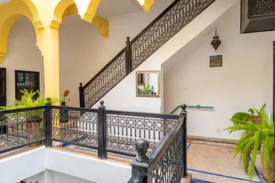 a staircase in a house with black railings at Riad Sharqi Luminous A Sunny in Marrakech Old Town in Marrakech