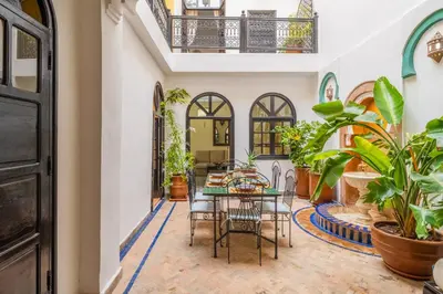 a dining room with a table and chairs and plants at Riad Sharqi Luminous A Sunny in Marrakech Old Town in Marrakech