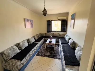 a living room with a couch and a table at Charmant Appartement à Gueliz - À Deux Pas des Attractions Locales in Marrakech
