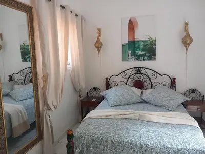 a bedroom with a bed and a mirror at Riad Camélia in Marrakech