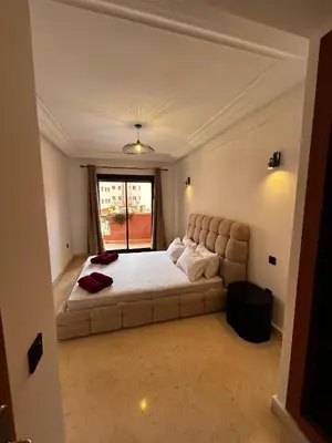 a bedroom with a large bed and a couch at Charmant Appartement à Gueliz in Marrakech