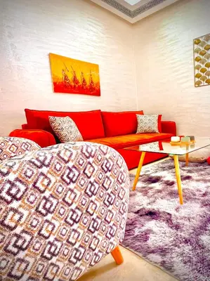 a living room with a red couch and a purple rug at Appartement LILIA in Marrakech