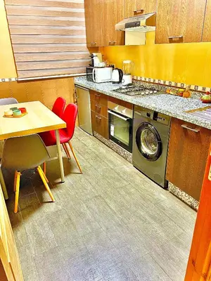 a kitchen with a washing machine and a table at Appartement LILIA in Marrakech