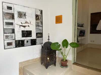 a room with a fireplace and a potted plant at Dar Ibo- Entire House- in Marrakech