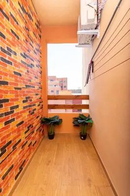 a hallway with a brick wall and two potted plants at Appartement en résidence fermée in Marrakech