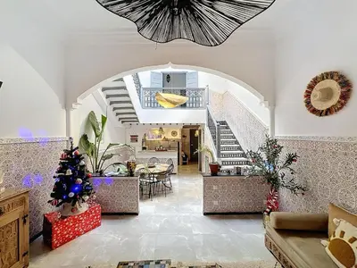 a living room with an archway and a staircase at Riad Beldi Chic Un Séjour Authentique Proche Médina in Marrakech
