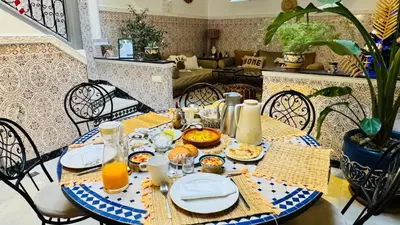 a table with plates of food and orange juice on it at Riad Beldi Chic Un Séjour Authentique Proche Médina in Marrakech