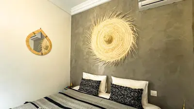a bedroom with a bed with black and white pillows at Riad Beldi Chic Un Séjour Authentique Proche Médina in Marrakech