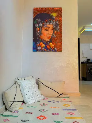 a painting of a woman on a wall with a pillow at Le Cocon doré avec terrasse ensoleillée au centre de Marrakech in Marrakech