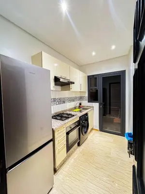 a kitchen with a stove and a refrigerator at Luxe et Douceur moderne, Parking Privé in Marrakech