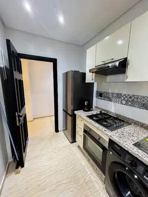 a kitchen with a stove and a refrigerator at Luxe et Douceur moderne, Parking Privé in Marrakech