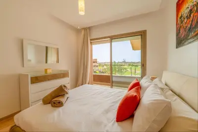 a bedroom with a bed with red pillows and a window at Relax Front of Panoraview Pool golf Atlas in Marrakech