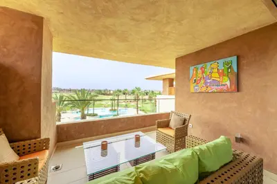 a living room with a couch and a table at Relax Front of Panoraview Pool golf Atlas in Marrakech