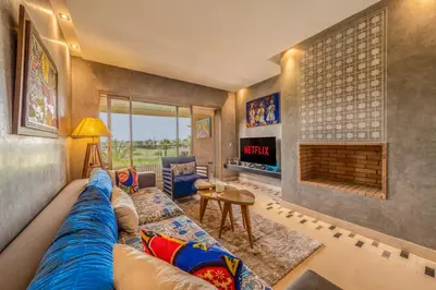 a living room with a blue couch and a fireplace at Relax Front of Panoraview Pool golf Atlas in Marrakech