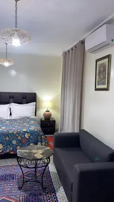a bedroom with a bed and a couch and a table at Raid Maison H in Marrakech