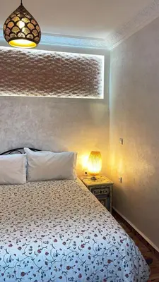 a bedroom with a bed and a lamp on a table at Raid Maison H in Marrakech