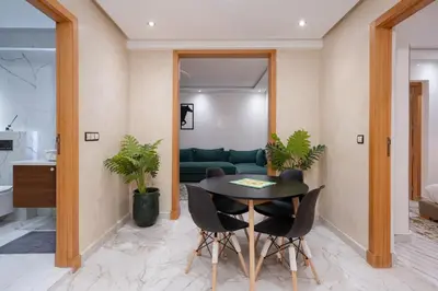 a kitchen and living room with a table and chairs at Bright Flat in Heart of Center in Marrakech