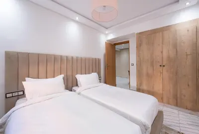 a bedroom with two beds and a wooden headboard at Bright Flat in Heart of Center in Marrakech