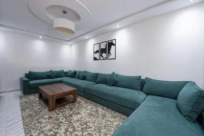 a living room with a blue couch and a table at Bright Flat in Heart of Center in Marrakech