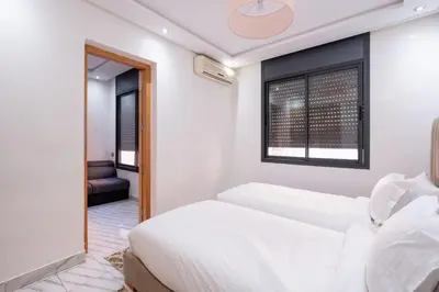 a bedroom with two beds and a window at Bright Flat in Heart of Center in Marrakech