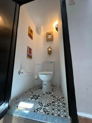 a bathroom with a toilet with a black and white tile floor at Riad Sala Art Marrakech in Marrakech