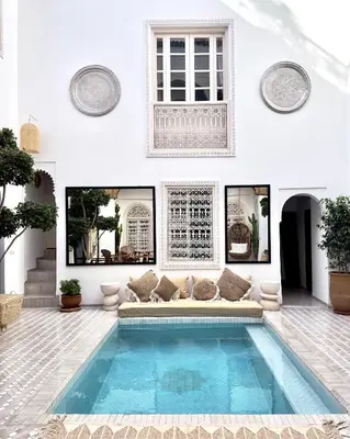 a living room with a pool in the middle of a house at Riad Jalma in Marrakech