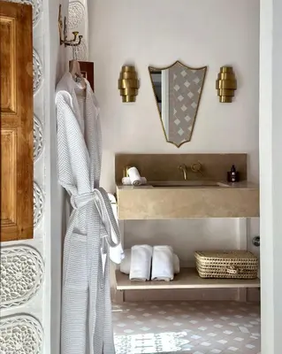 a bathroom with a sink and a shelf with towels at Riad Jalma in Marrakech